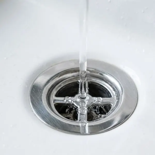 Clear water draining quickly down a clean and polished bathroom sink.