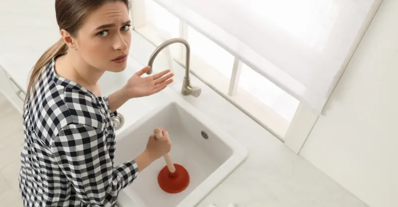 Woman plunging her kitchen sink