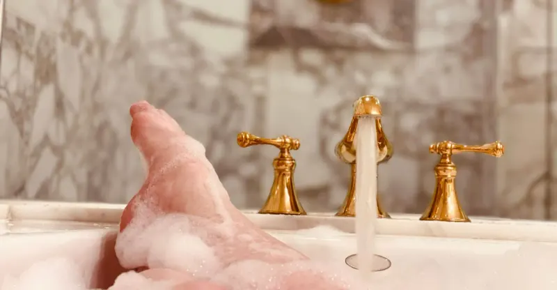 running bathtub with gold fixtures