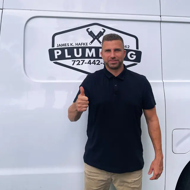 A Hafke Plumbing customer photographed beside a Hafke service van after a completed job