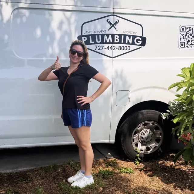 A Hafke Plumbing customer photographed beside a Hafke service van after a completed job