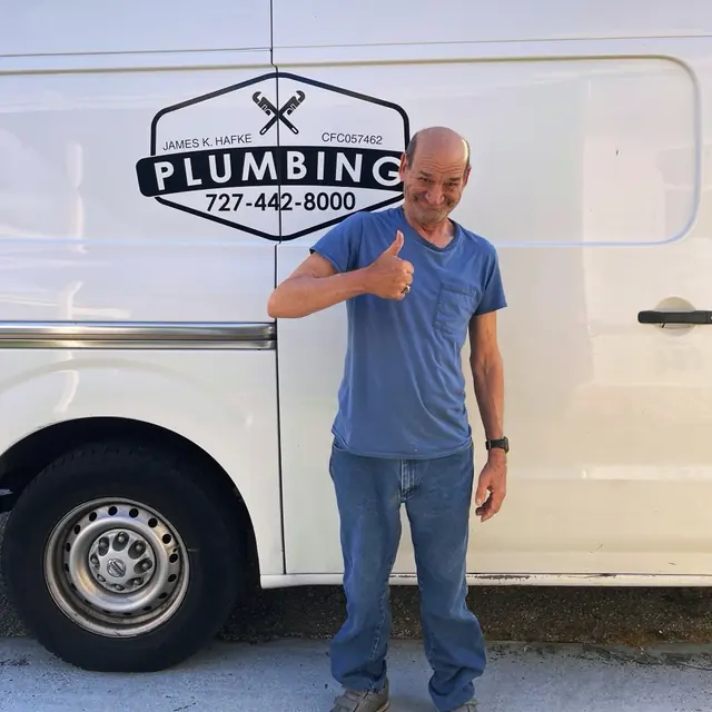 A Hafke Plumbing customer photographed beside a Hafke service van after a completed job