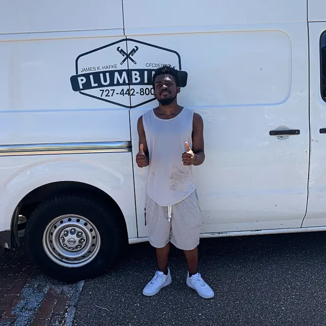 A Hafke Plumbing customer photographed beside a Hafke service van after a completed job