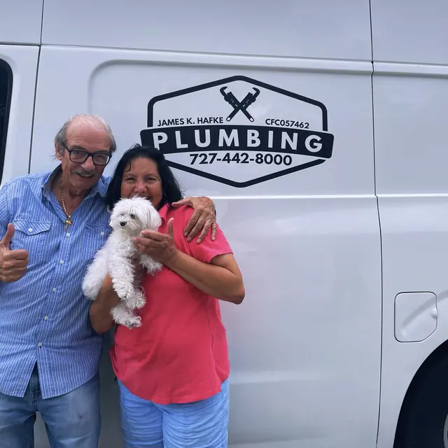 A Hafke Plumbing customer photographed beside a Hafke service van after a completed job