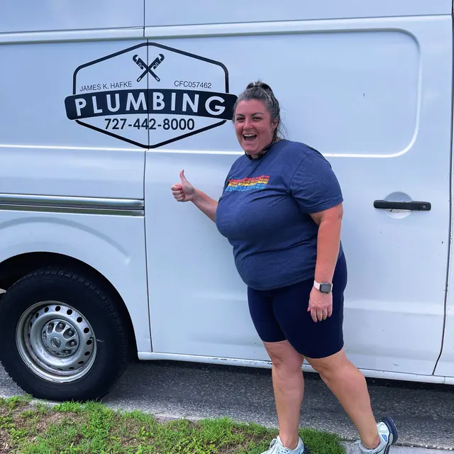 A Hafke Plumbing customer photographed beside a Hafke service van after a completed job