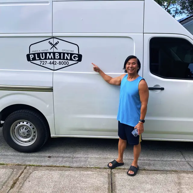 A Hafke Plumbing customer photographed beside a Hafke service van after a completed job