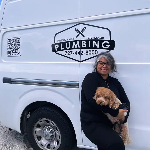 A Hafke Plumbing customer photographed beside a Hafke service van after a completed job