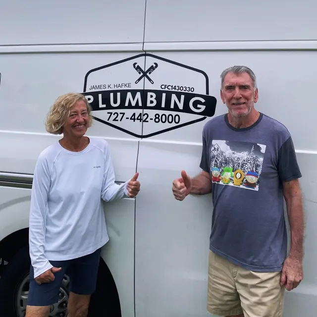 A Hafke Plumbing customer photographed beside a Hafke service van after a completed job