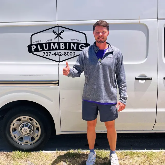 A Hafke Plumbing customer photographed beside a Hafke service van after a completed job