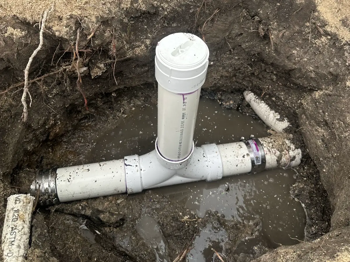 Drain cleanout excavated beside a commercial grease trap