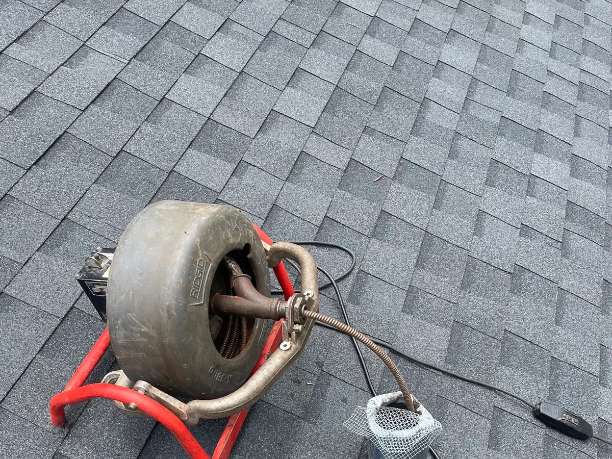 Drain machine set up at a roof vent during a jetting job
