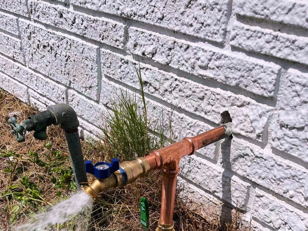 Water running from an outdoor spigot during a leak check