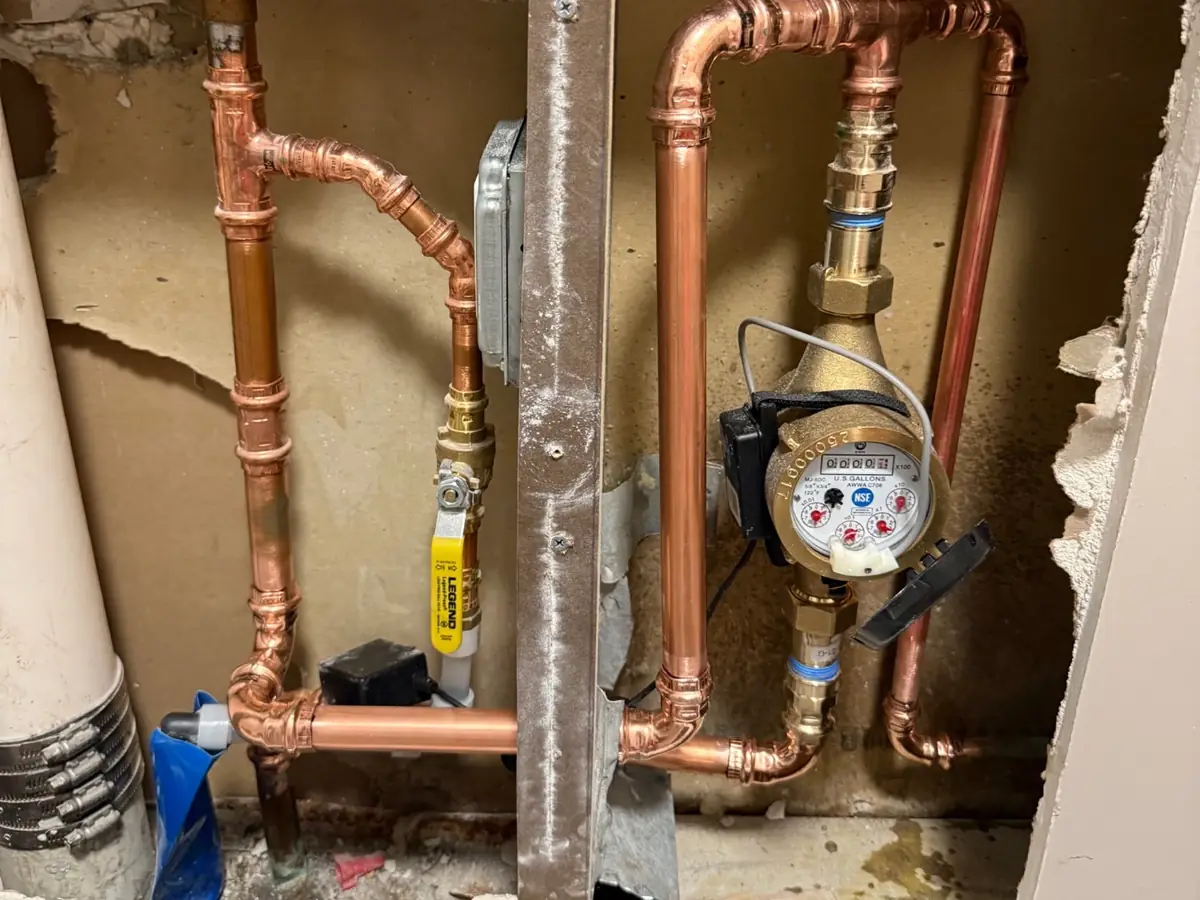 Copper repiping and water meter exposed in an open wall