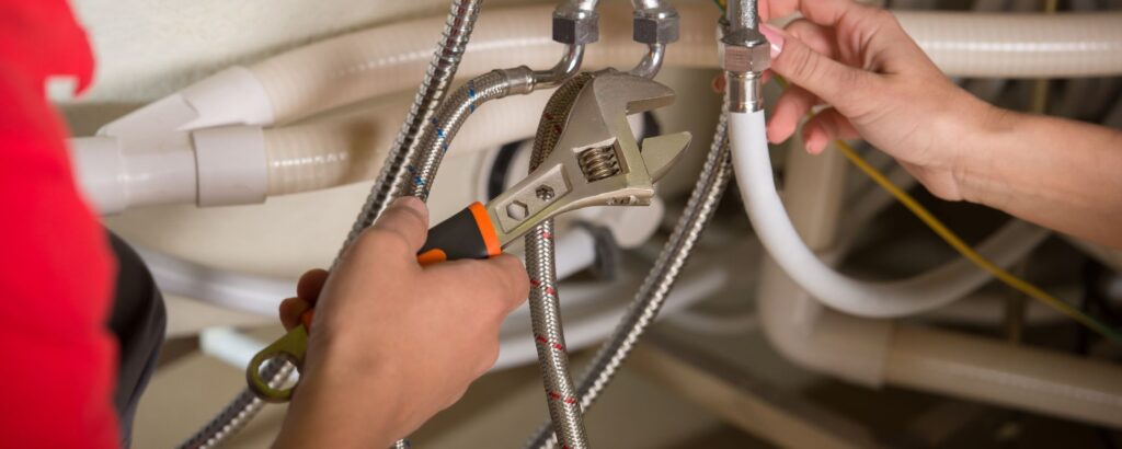 plumber adjusting pipes under sink