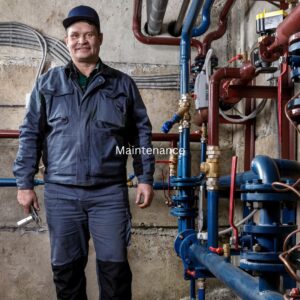 smiling plumber next to pipes