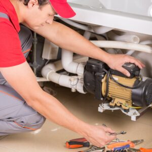 plumber looks at water pump system 