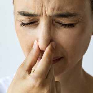 person holding her nose because of a bad odor