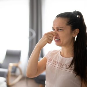 Woman holding her nose