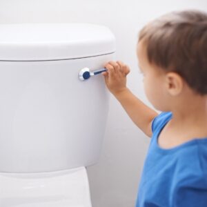 Boy flushing a toilet