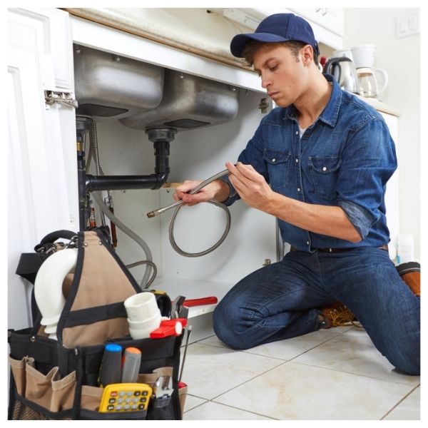 plumber working under sink