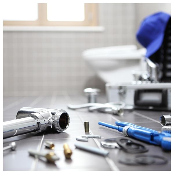 plumbing tools laid out on bathroom floor