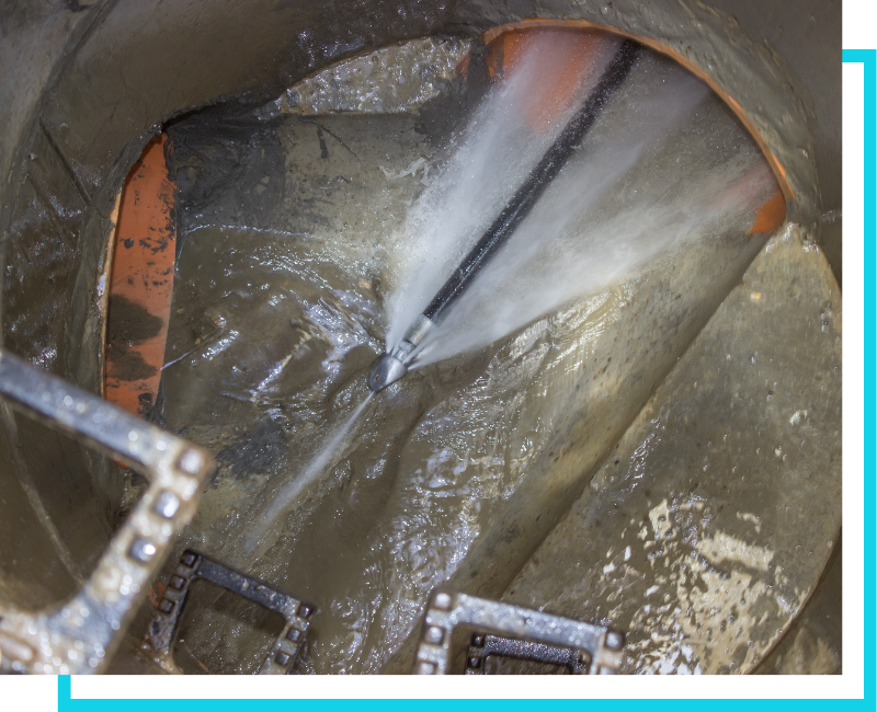 High-pressure water jetting nozzle cleaning a commercial sewer line to remove grease and stubborn blockages.