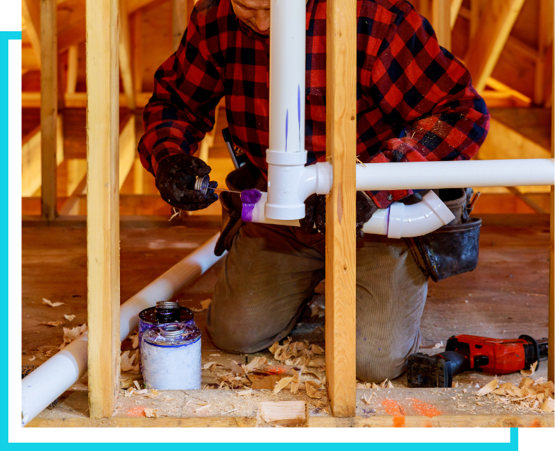Licensed plumber applying PVC primer and cement to water supply lines during a commercial rough-in in St. Petersburg.