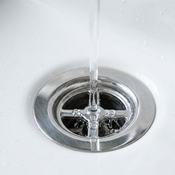 Clear water draining quickly down a clean and polished bathroom sink.